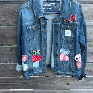 Stylish Denim Jacket with Heart Patches by “Jagged Threads”
